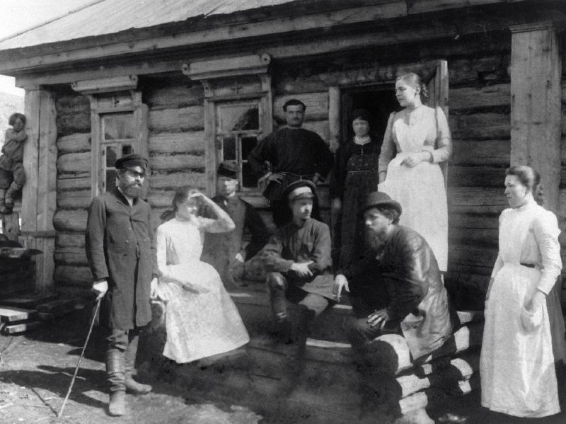Сестры милосердия стоят на крыльце дома с местными жителями. Санитарный поезд в селе Нарукееве, голодный год, 1891-1892  