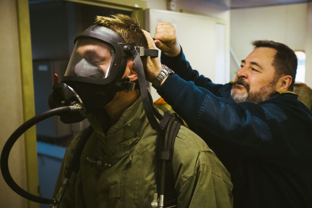 Сергей Михайлович помогает студенту затянуть кислородную маску