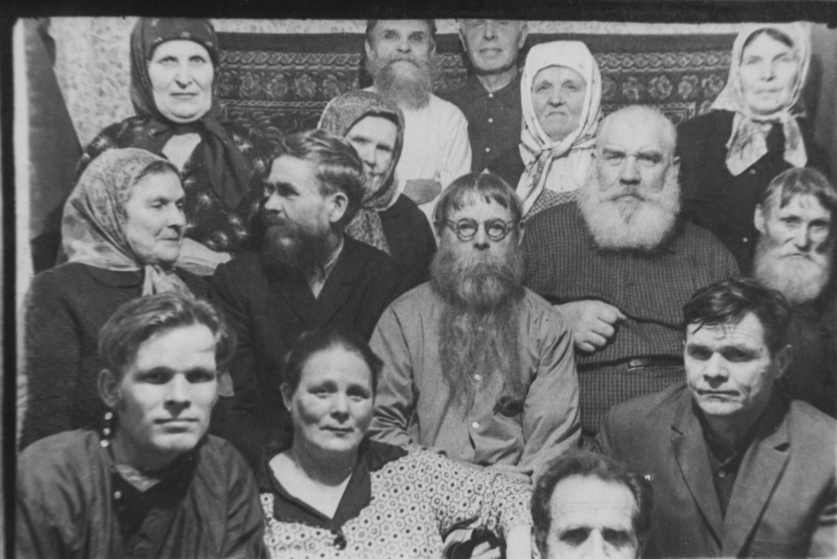  На старой черно-белой фотографии группа деревенских мужчин и женщин