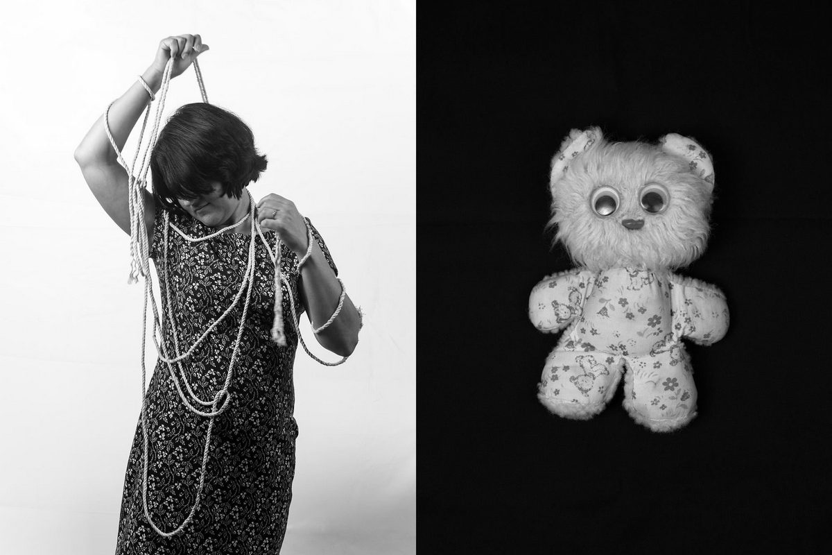  Черно-белое фото разделено на две части. Слева молодая женщина в платье, волосы скрывают лицо, в странной позе с поднятыми руками, как будто распутывает связывающую ее верёвку. Справа - мягкая игрушка.
